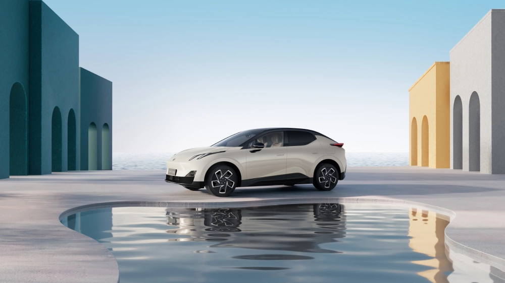 A Lynk & Co 02 E-SUV with a white exterior against a minimalist coastal background.