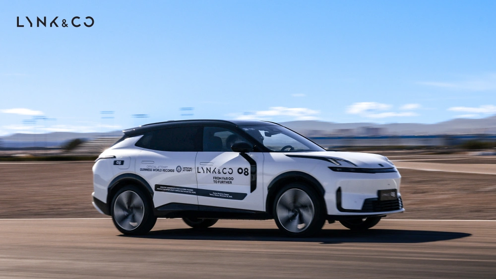 A white Lynk & Co 08 EM-P speeding on a track showcasing its official Guinness World Records achievement.