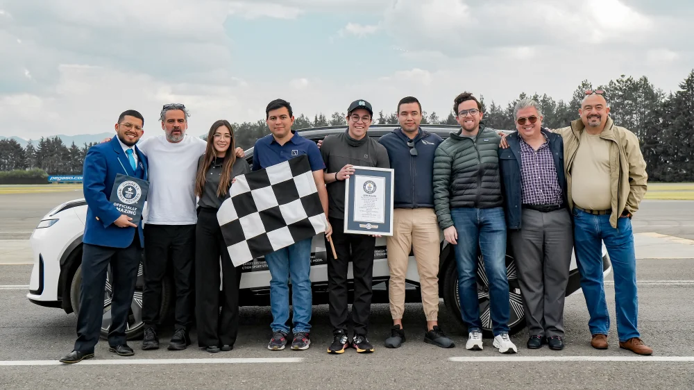 The team poses with a Guinness World Records certificate beside the white Lynk & Co 08 EM-P.
